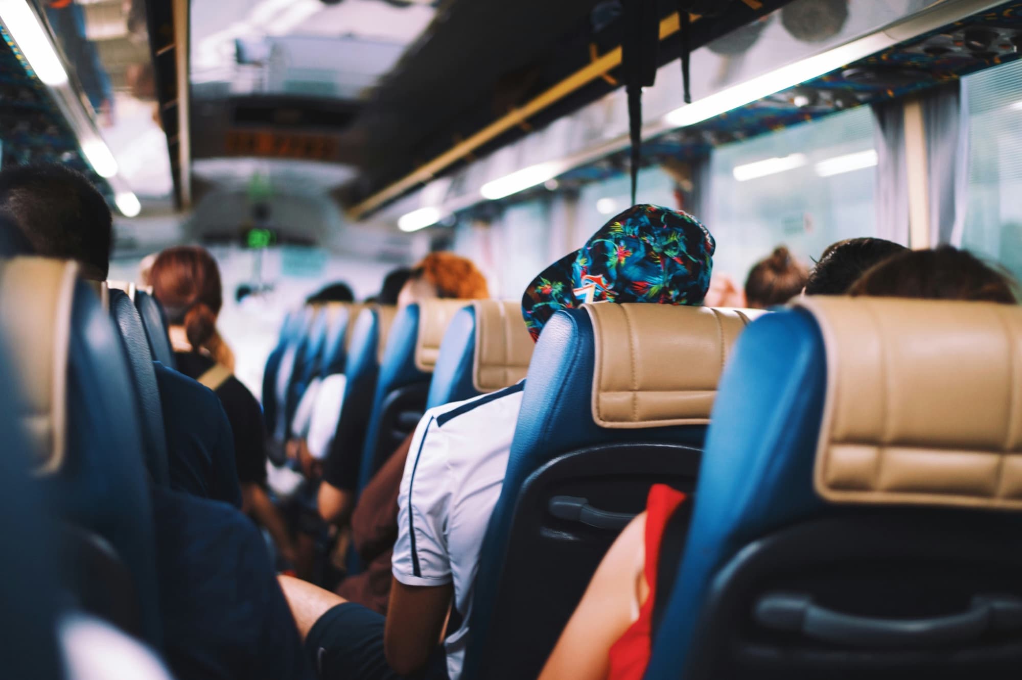 Besetzte Sitzreihen in einem Reisebus während der Fahrt
